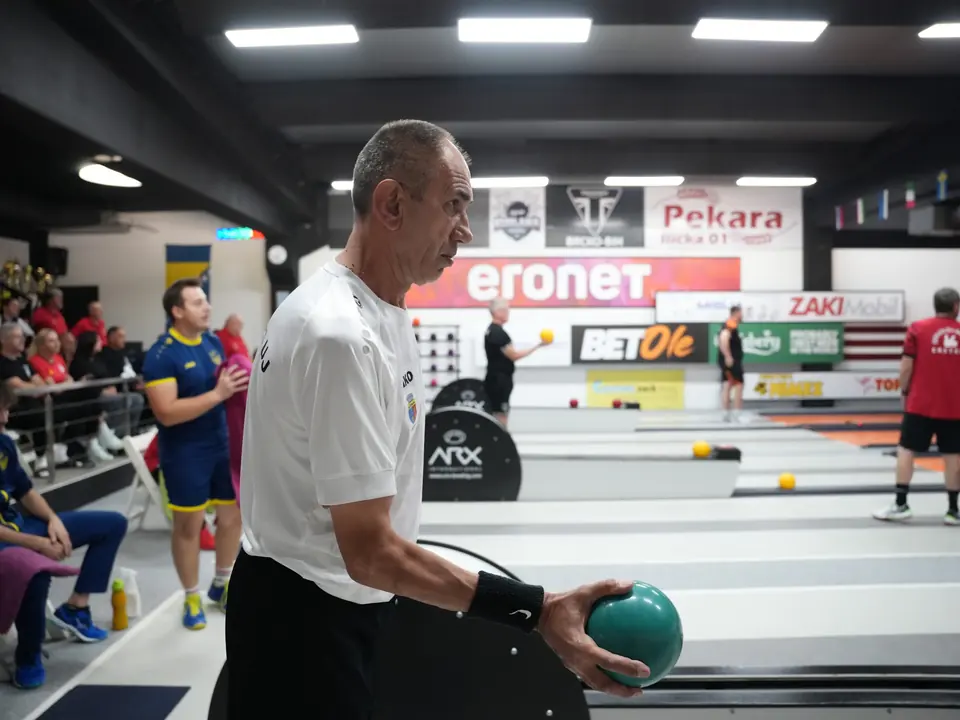 Takmičar priprema bacanje zelenom kuglom